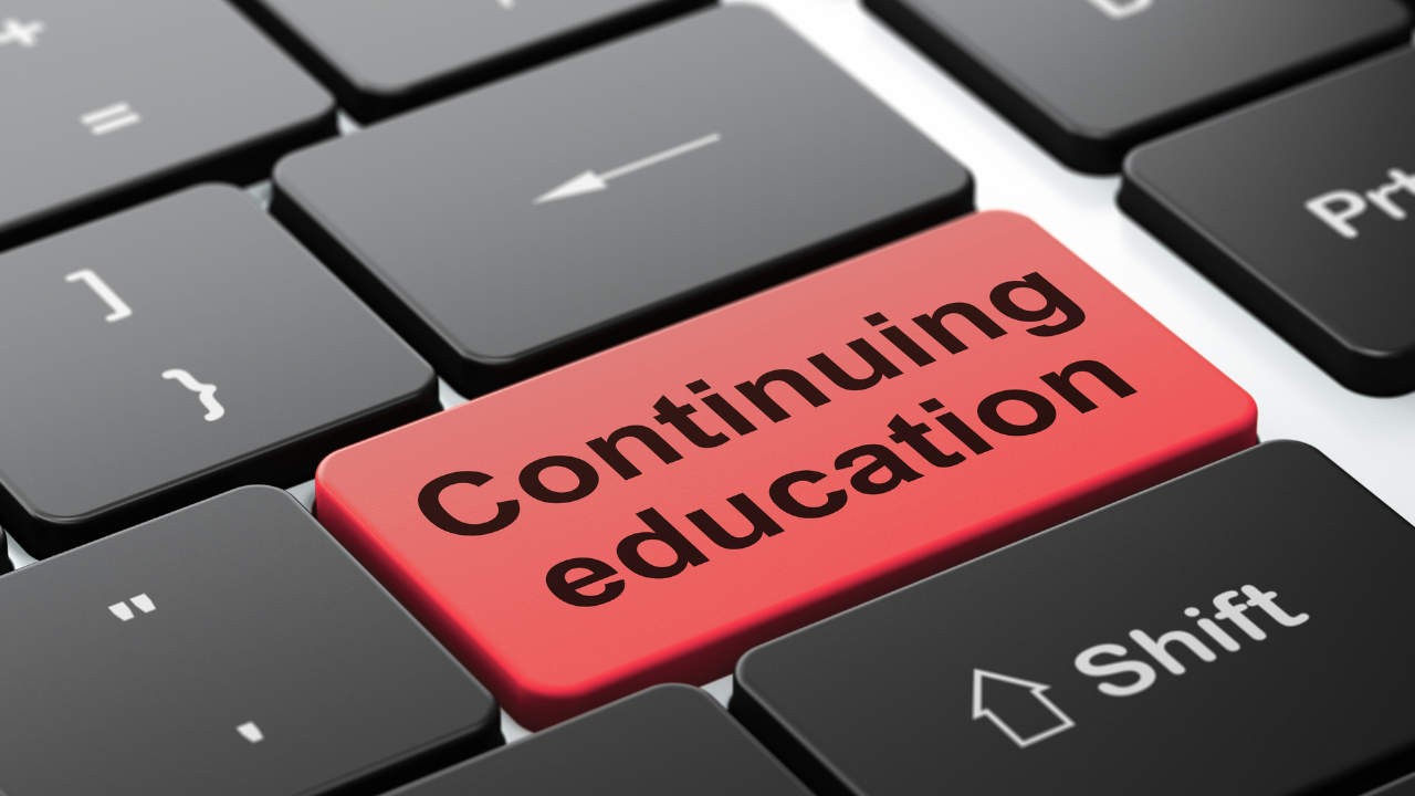 Close-up of a computer keyboard with a red key labeled 'Continuing Education' in black text.