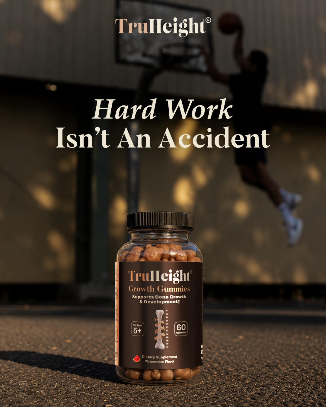 A bottle of TruHeight Growth Gummies on the ground with a basketball hoop and a person jumping to shoot a basketball in the background. The image has a motivational message, "Hard Work Isn’t An Accident," overlayed.