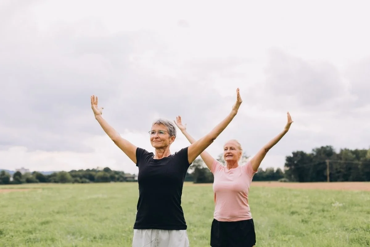 Two women doing yoga outside
