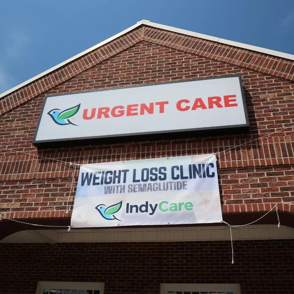 Brick building with a large sign that reads 'Urgent Care' and a banner below advertising a weight loss clinic with Semaglutide from IndyCare hung on the IndyCare Kannapolis location
