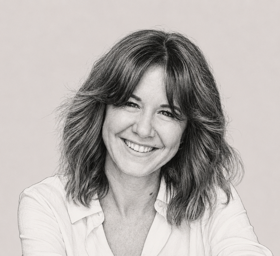 Black and white portrait of woman with shoulder-length wavy hair, smiling, wearing a collared shirt against a plain background.