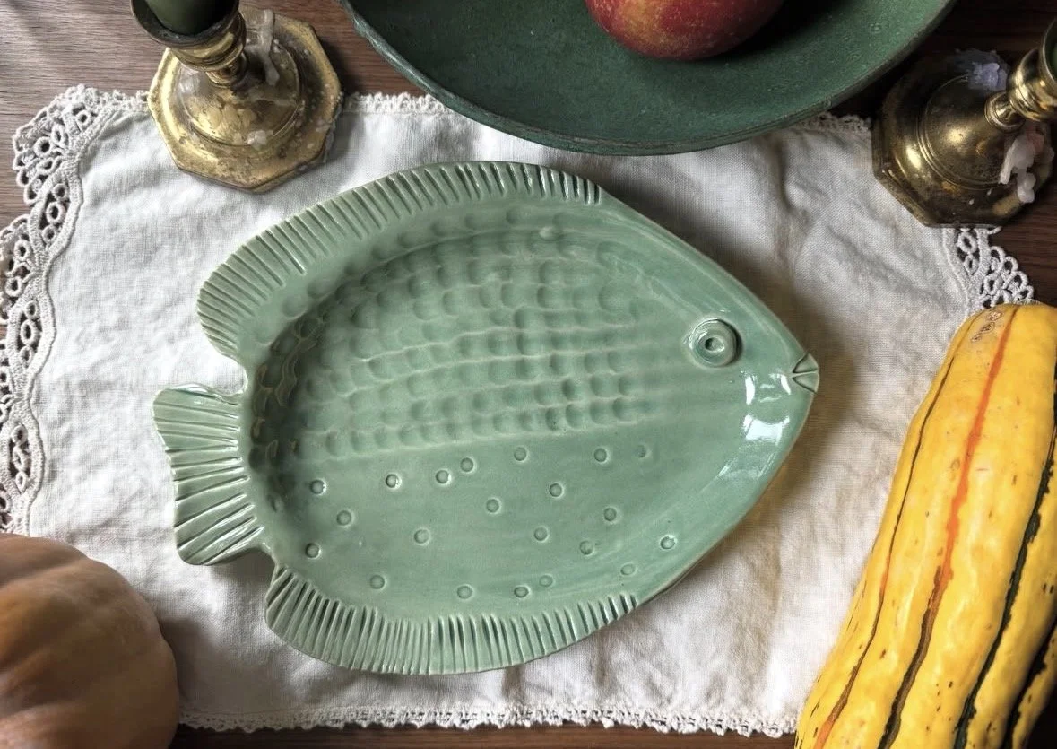 A green fish dish on a kitchen table