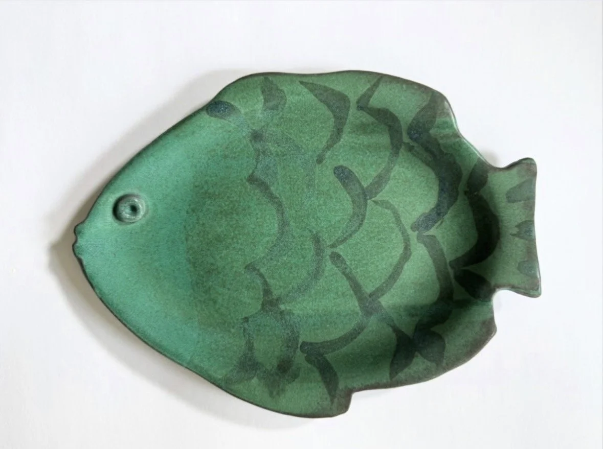 A fish-shaped decorative object with green gradient and dark green markings, resembling a tropical fish.