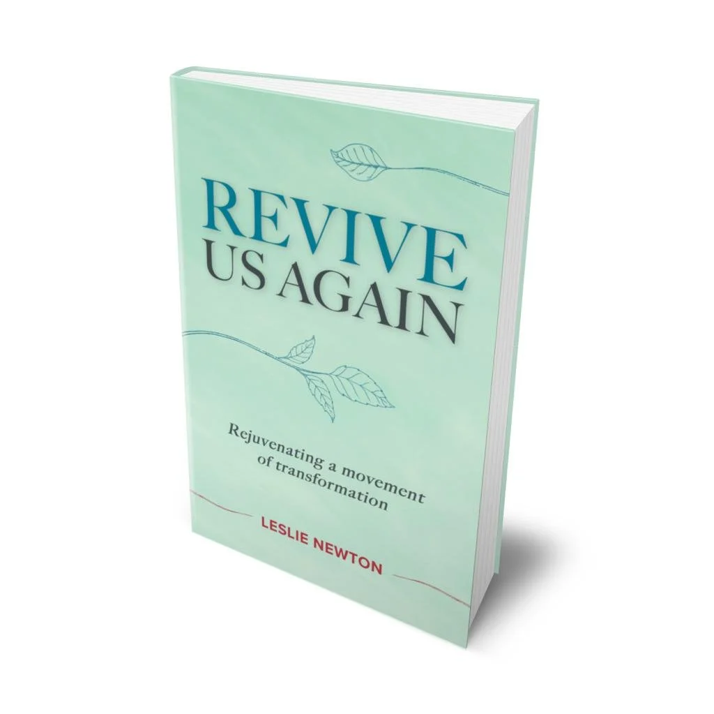 Book titled 'Revive US Again' by Leslie Newton, with a light green cover and delicate leaf illustrations, about rejuvenating a movement of transformation.