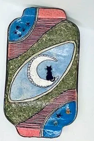 Cat tray sitting on a moon with cat faces on one corner and paw prints on the other