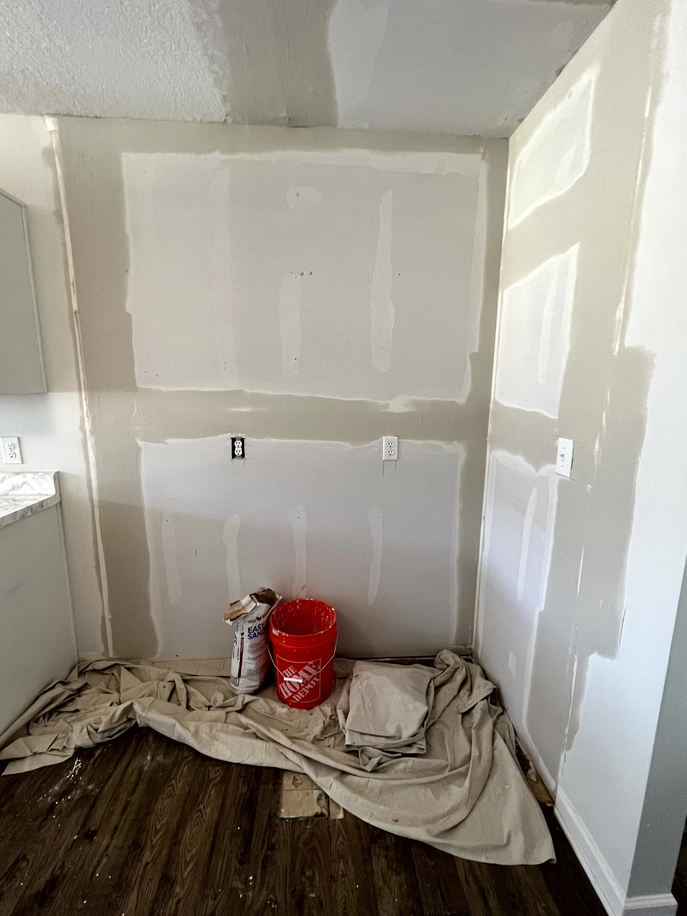  The other side of the kitchen wall with the old pantry also drywalled in. drop clth and supplies still on the floor  