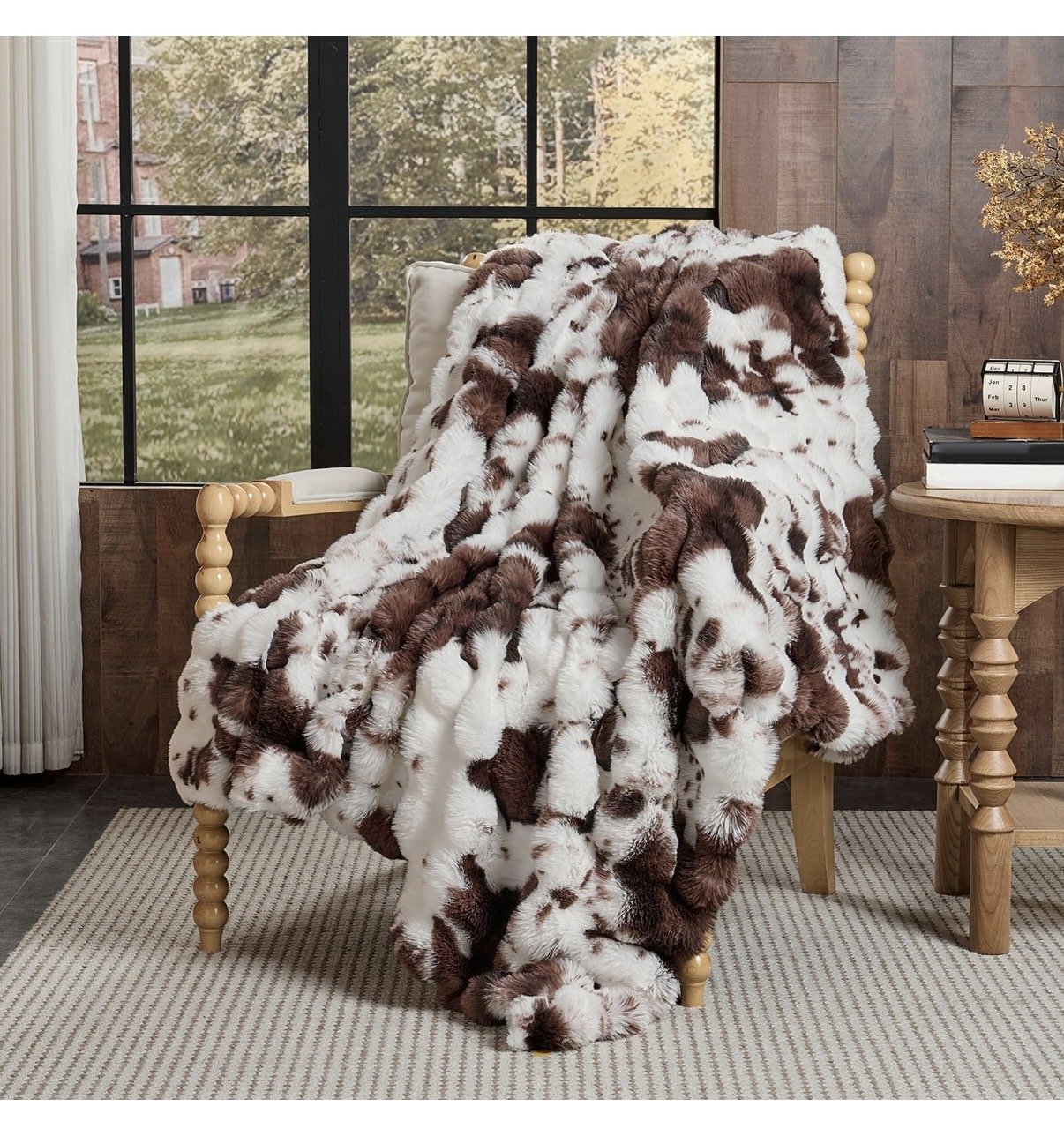  An amazon stock image of a  brown and white cow print fluffy throw blanket.  