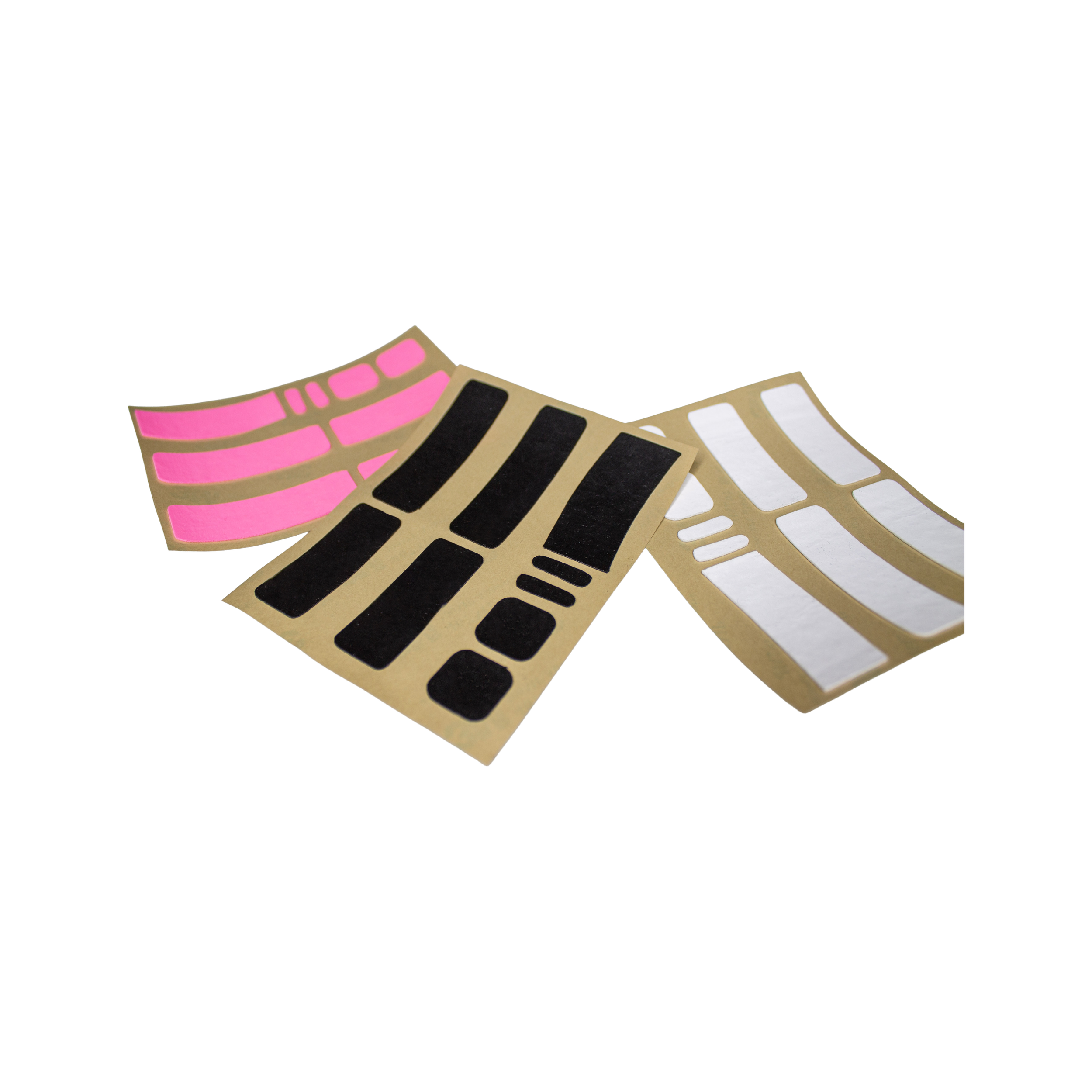 Colorful, curved adhesive sticker sheets with pink, black, and white rectangular grips on beige backing, fanned out on a flat surface.