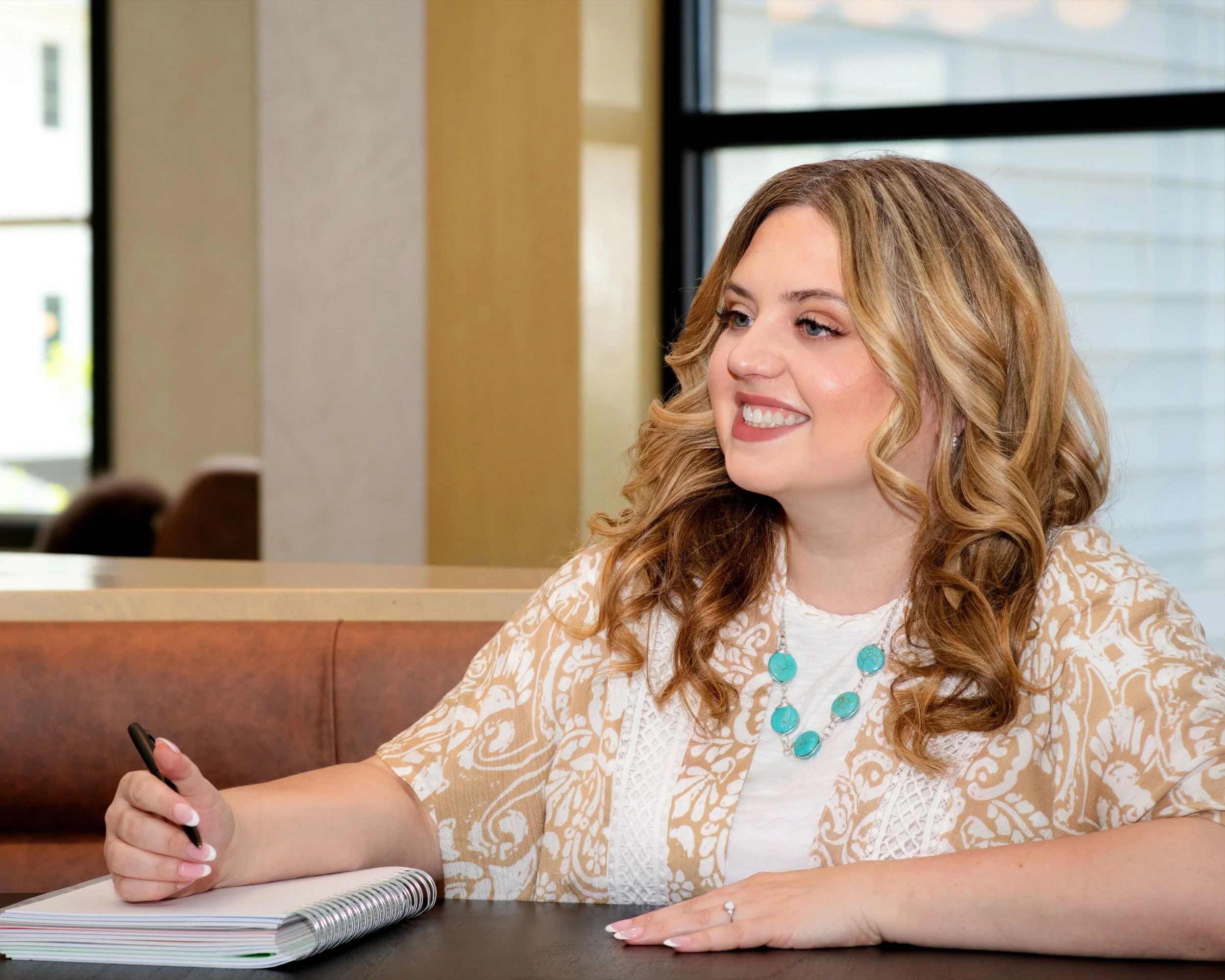 Shana Reiss, LCSW, smiling while taking notes at a table