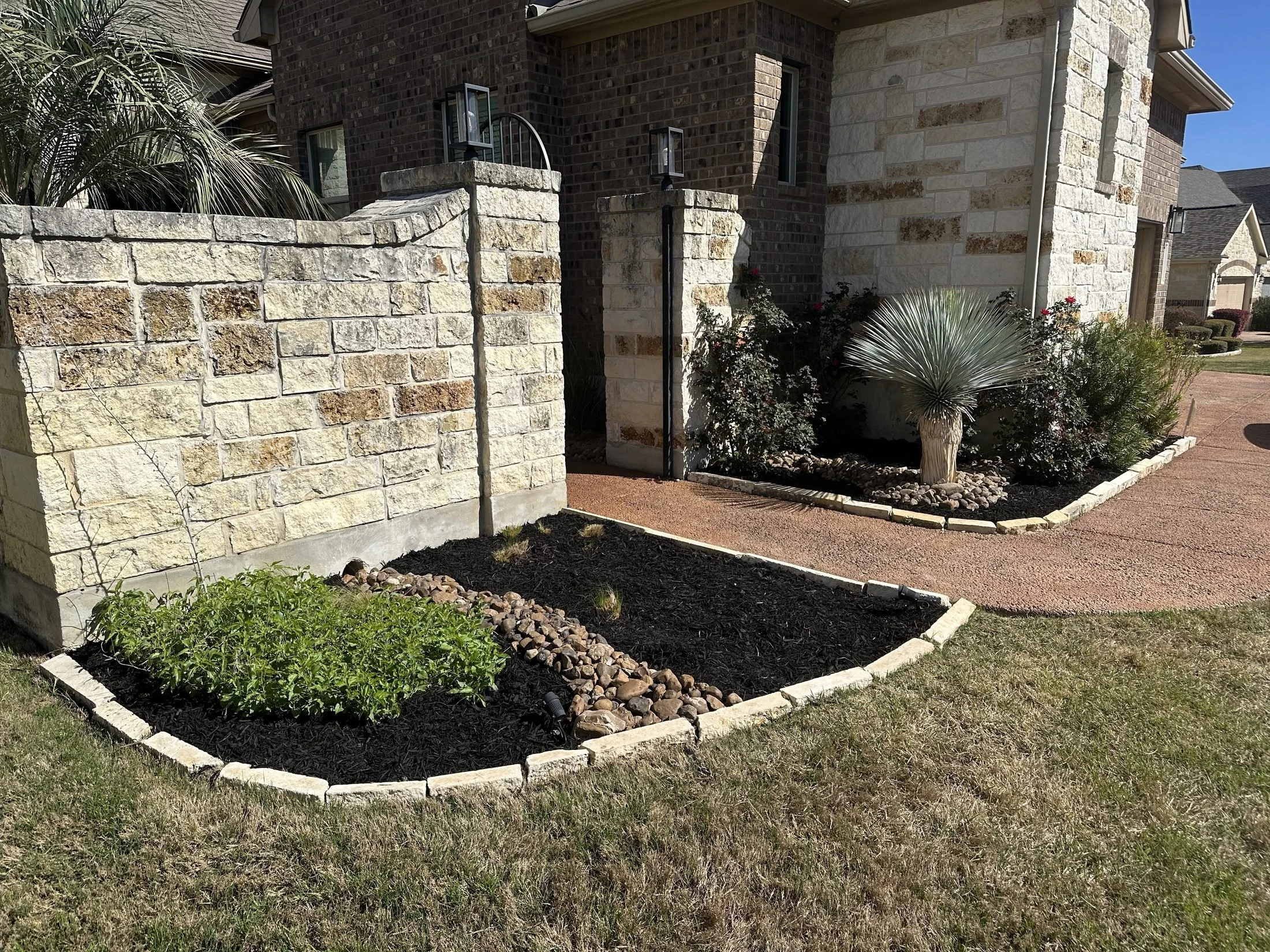 Curved stone-edged planting bed and walkway at a San Antonio home