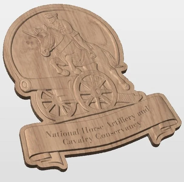 Wooden plaque with an etched design of a Native American riding a horse-drawn cart, with a banner reading "National Horse Artillery and Cavalry Conservancy."