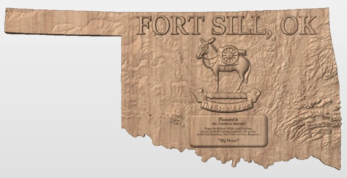 Wooden plaque with the text "Fort Sill, OK" and a carved image of a donkey with a cannon wheel on its back, and a banner below reading "Big Dipper."