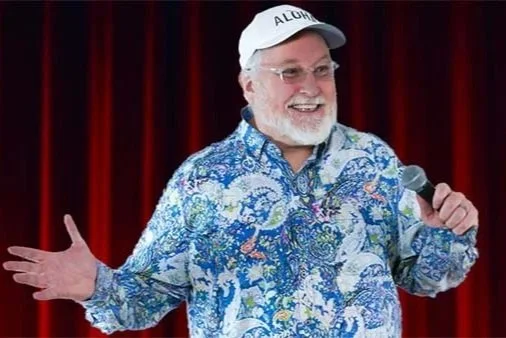 Kevin Wanzer on stage wearing a colorful shirt