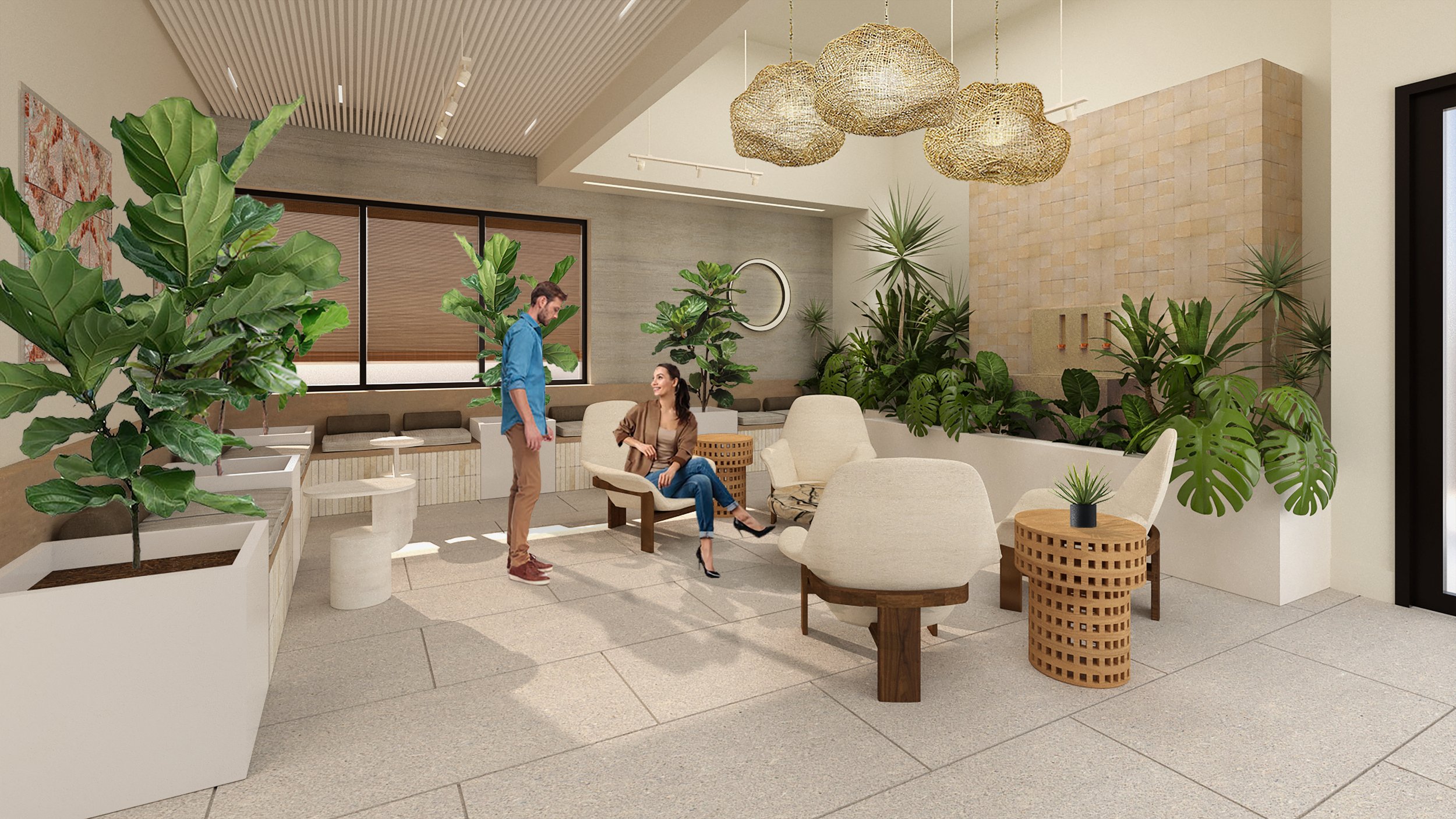 A modern indoor lounge area with greenery, beige furniture, and decorative lighting. Two people are interacting; one sitting on a chair and the other standing nearby.