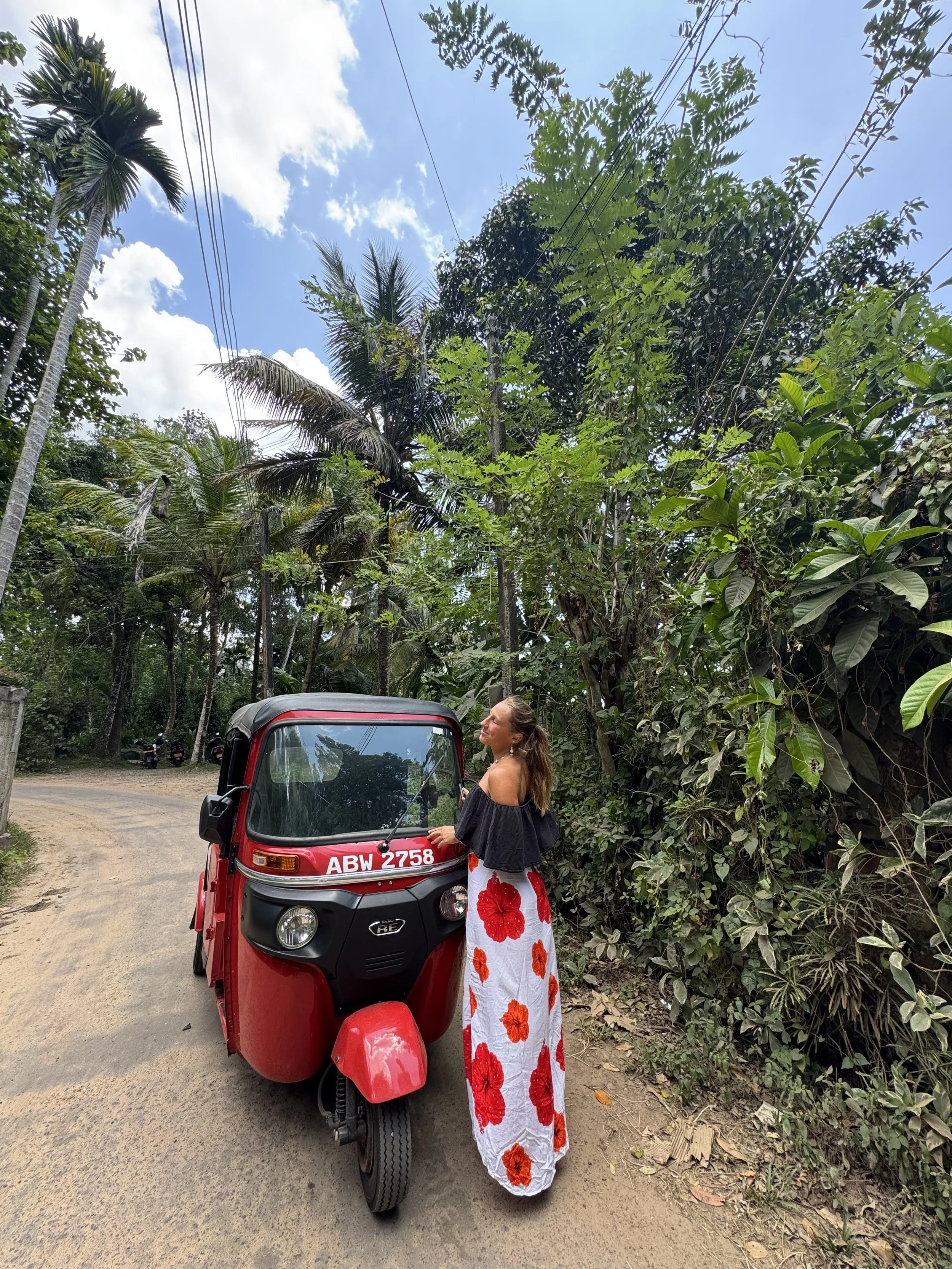 Lara standing next to a red tuktuk in Ahangama, Sri Lanka