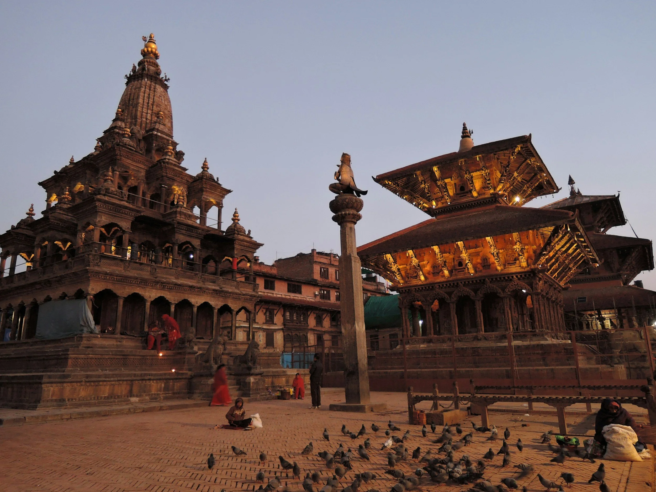 Ornately carved wooden pagoda temples in Kathmandu's Durbar Square, Nepal, lit up at dusk