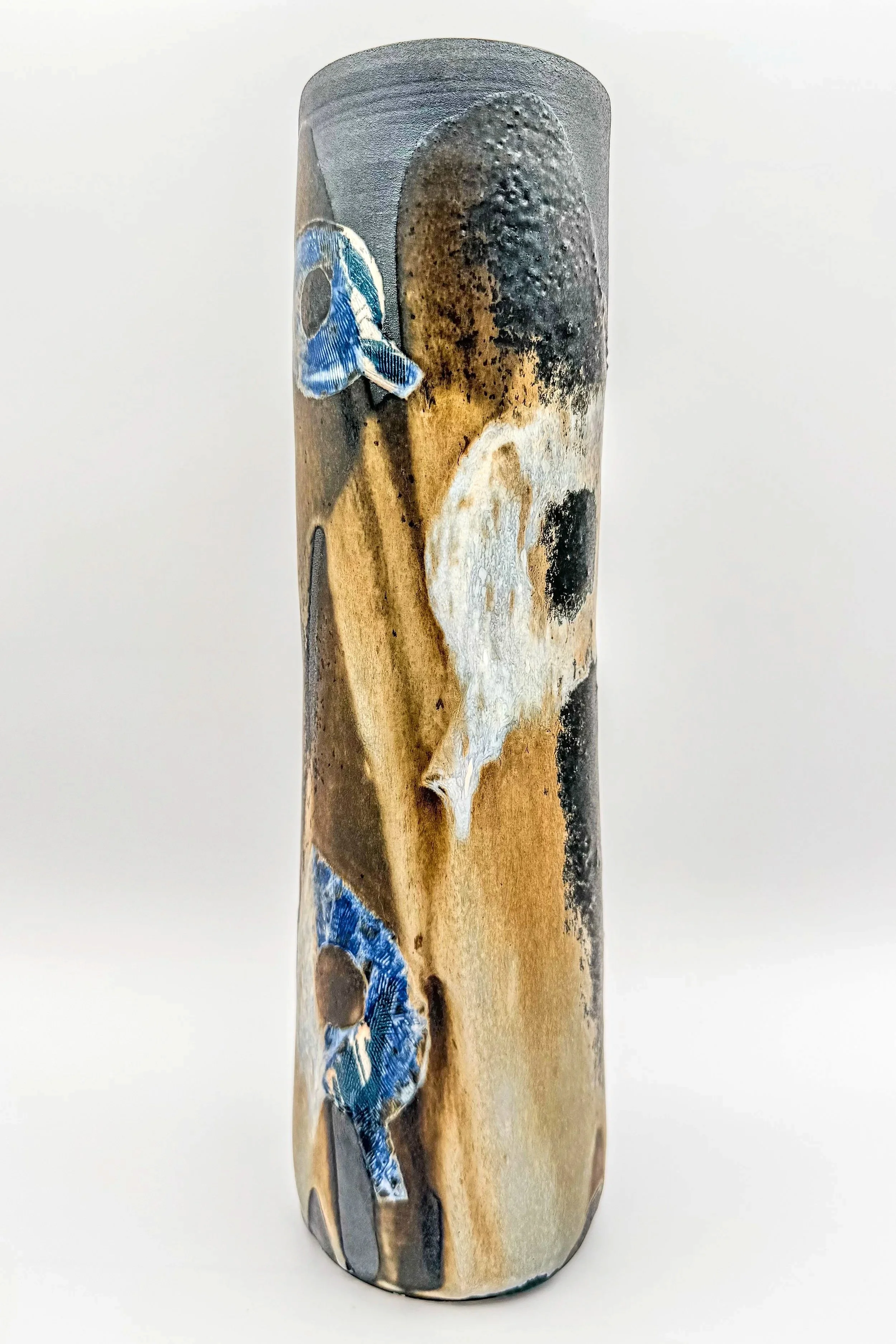 Ceramic vase with abstract glazed design in black, white, beige, and blue colors.