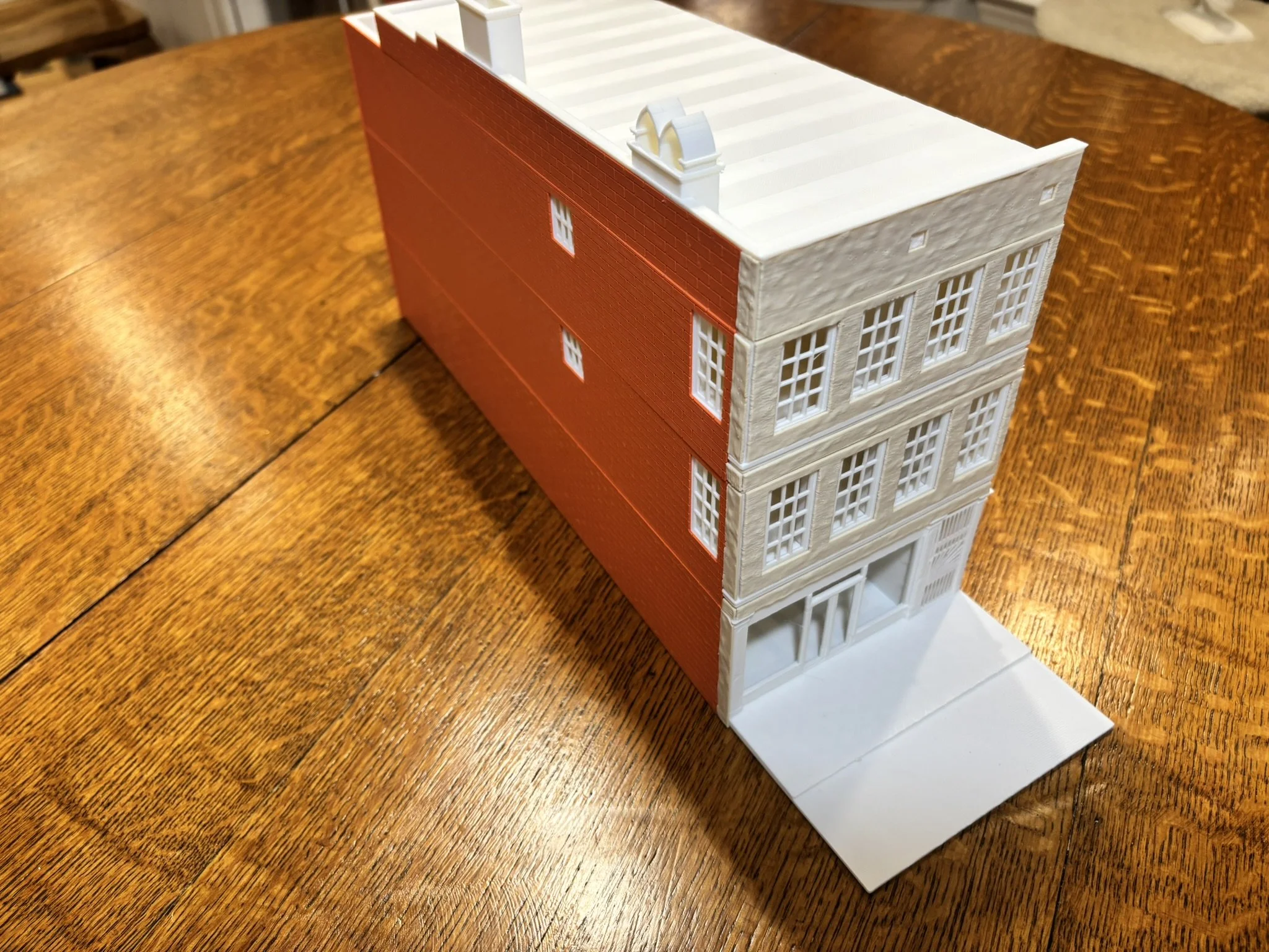 A detailed model of a multi-story building with red brick exterior and white architectural elements.