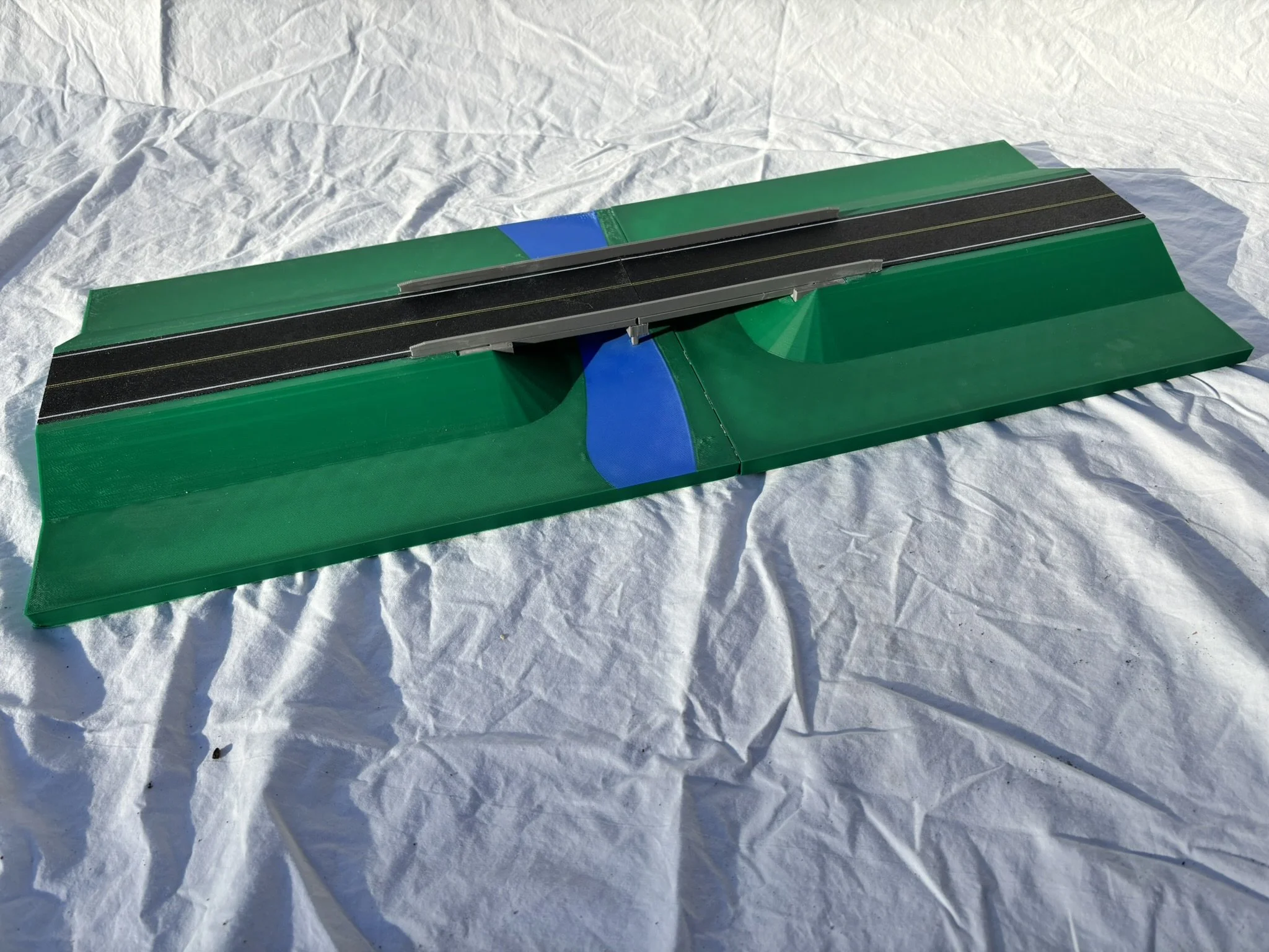 A large format model of a road with green and black surfaces.