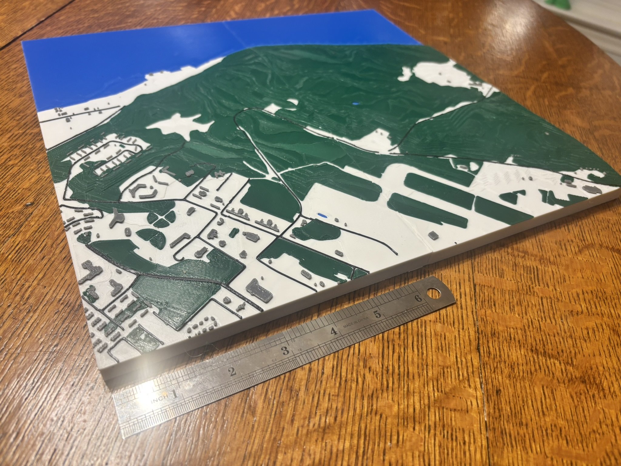 A 3D diorama featuring ocean, airfields, and landscaping.
