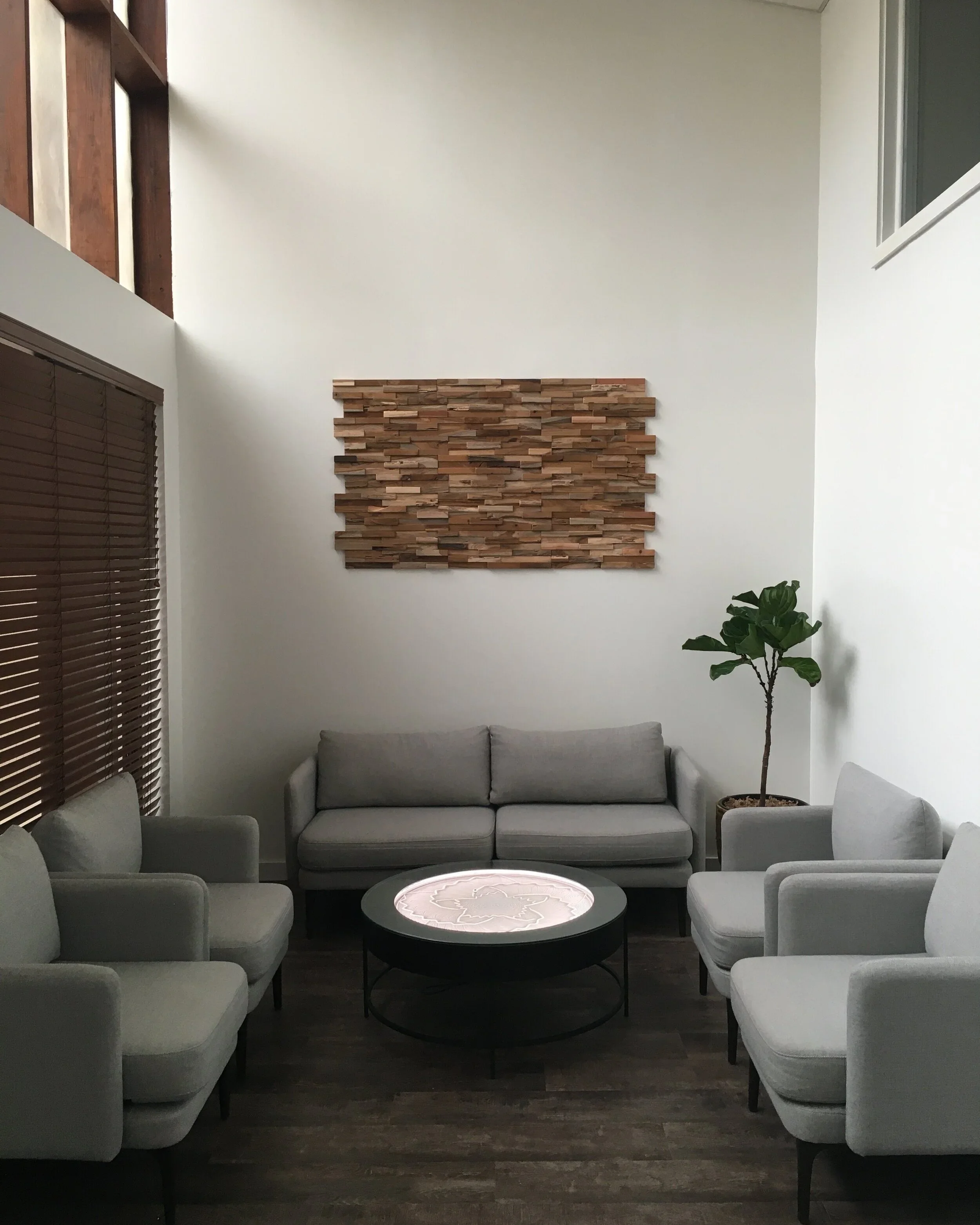 Waiting room of Aspen Health with chairs, table, and plant