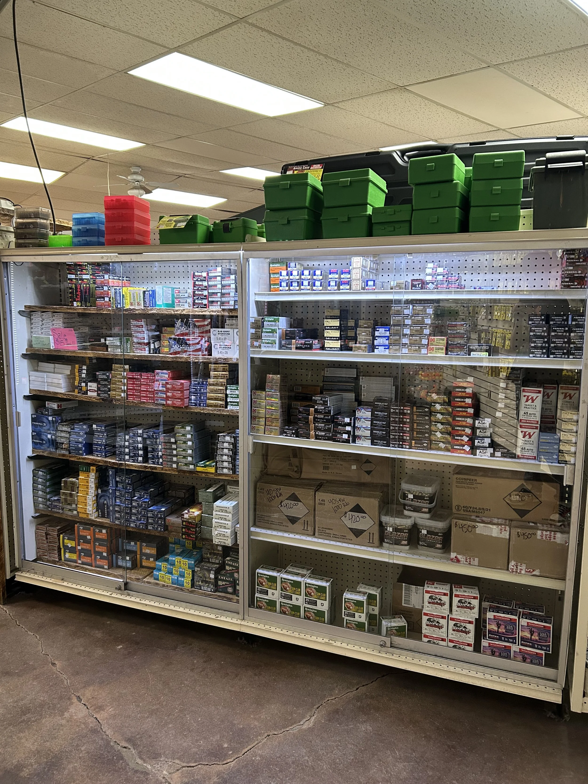 A display case filled with various types of ammunition, including bullets and cartridges, in a store setting.