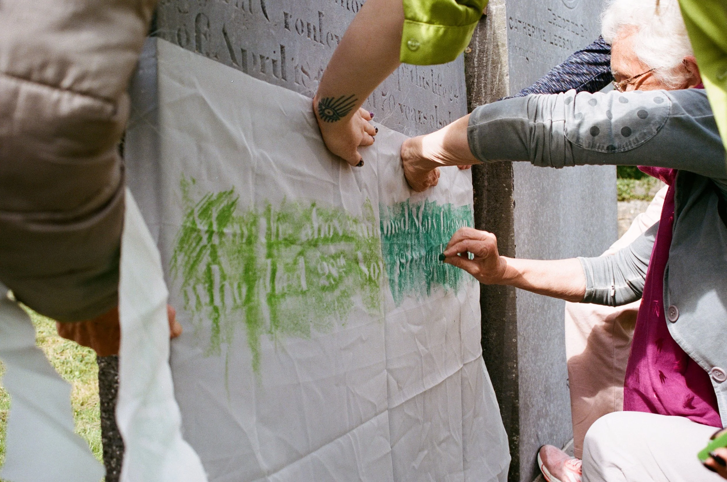 People taking a scratching from the stone work on a grave