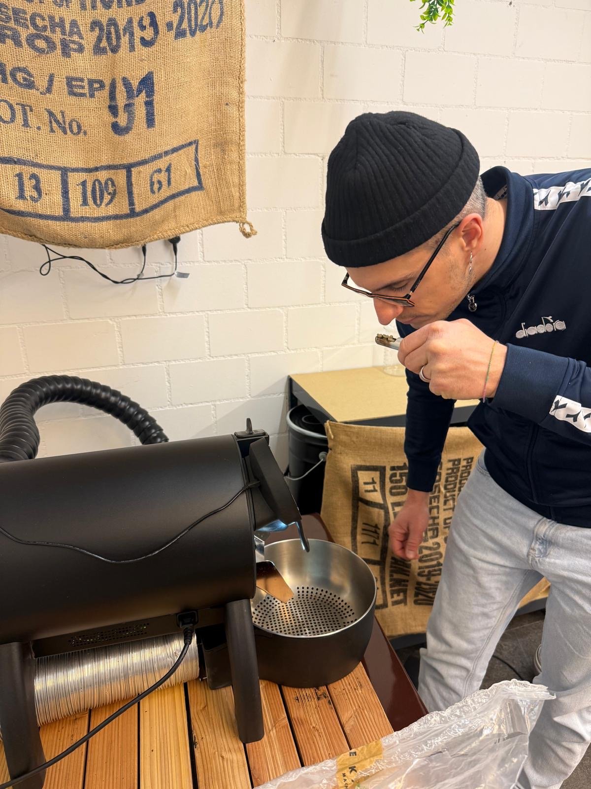 Ein Mann bedient eine Kaffee-Maschine, während er sich bückt und eine Kaffeekapsel in die Maschine einlegt.