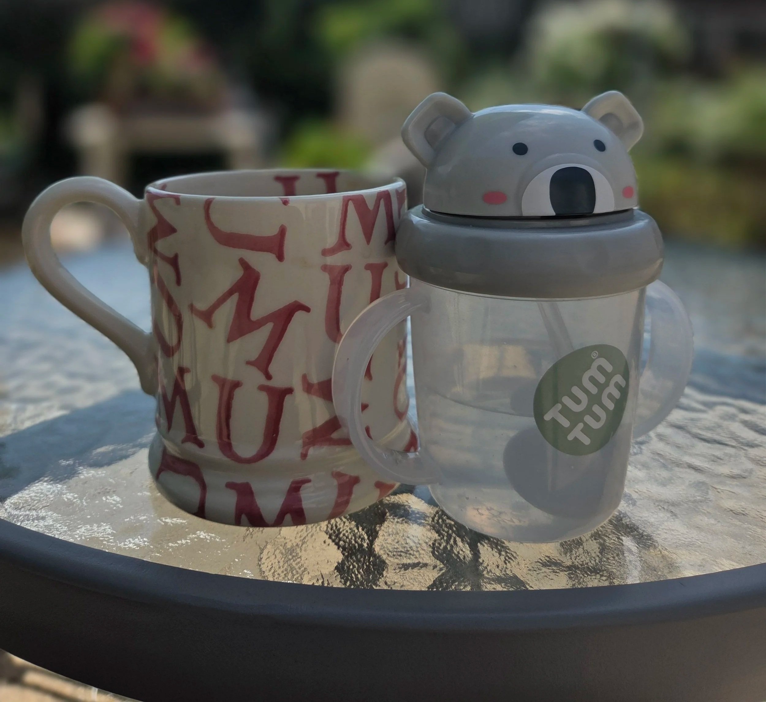A mum mug and child’s cup together in the garden