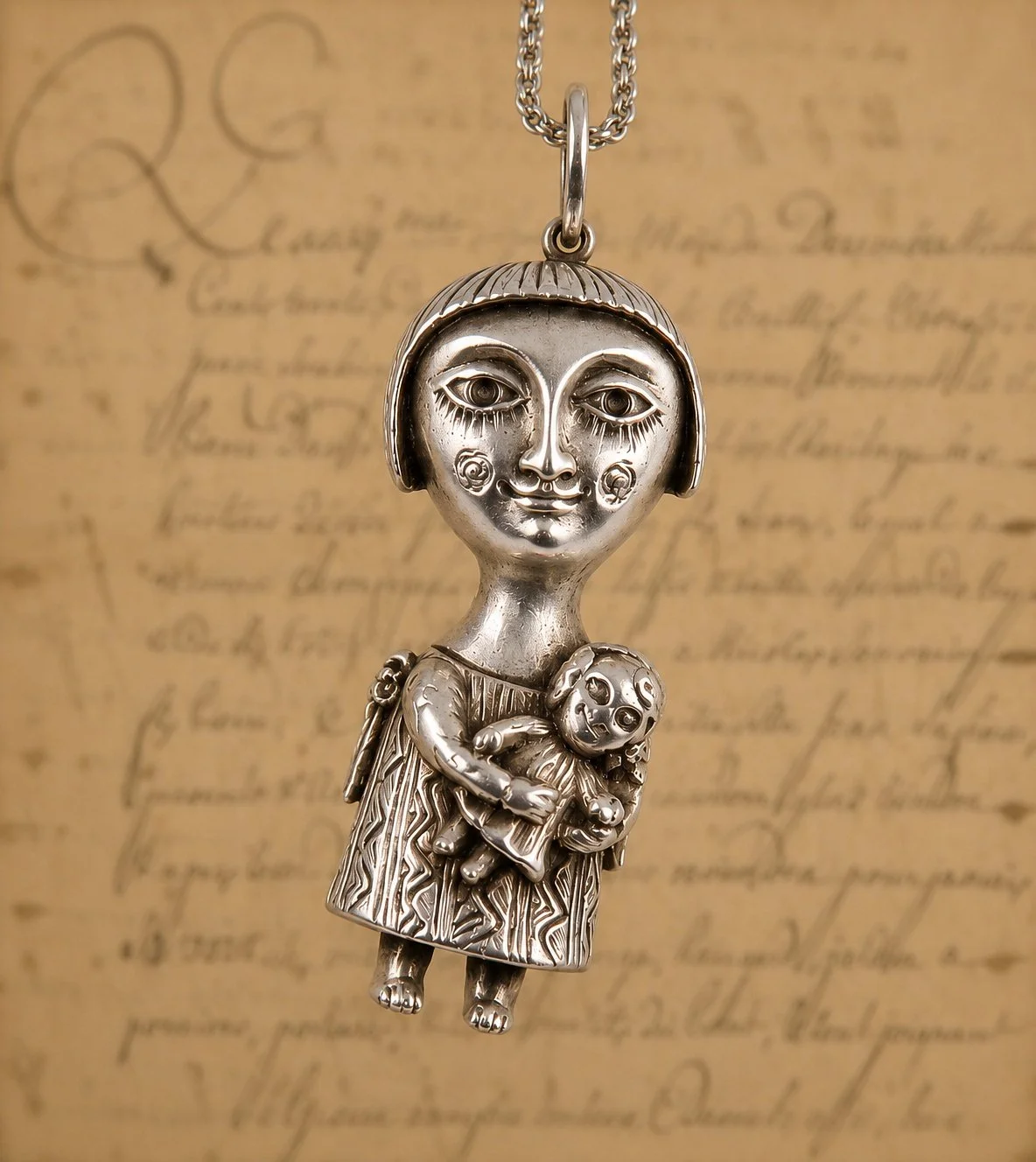 Silver pendant depicting a girl with a bob haircut holding a teddy bear, hanging on a chain, positioned in front of a handwritten letter background.