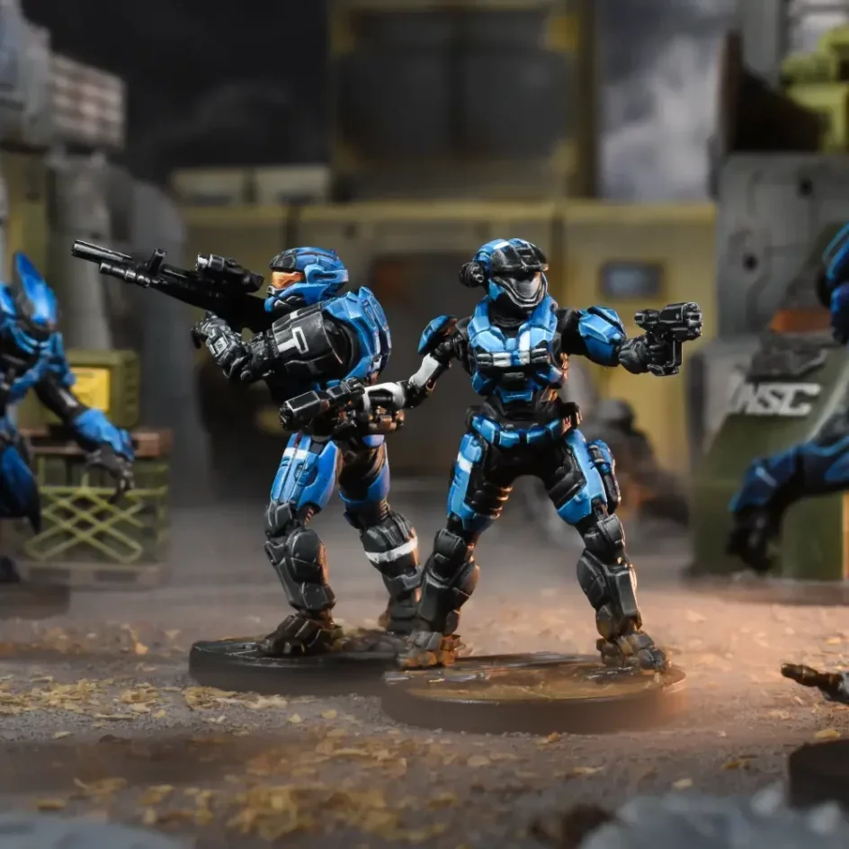 Two action figures in blue armor holding guns in a sci-fi setting.