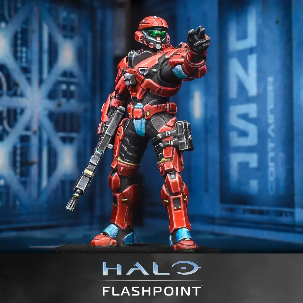 A detailed action figure of a red and black armored soldier from Halo, holding a gun and gesturing with his hand, against a blue background with Halo Flashpoint branding.