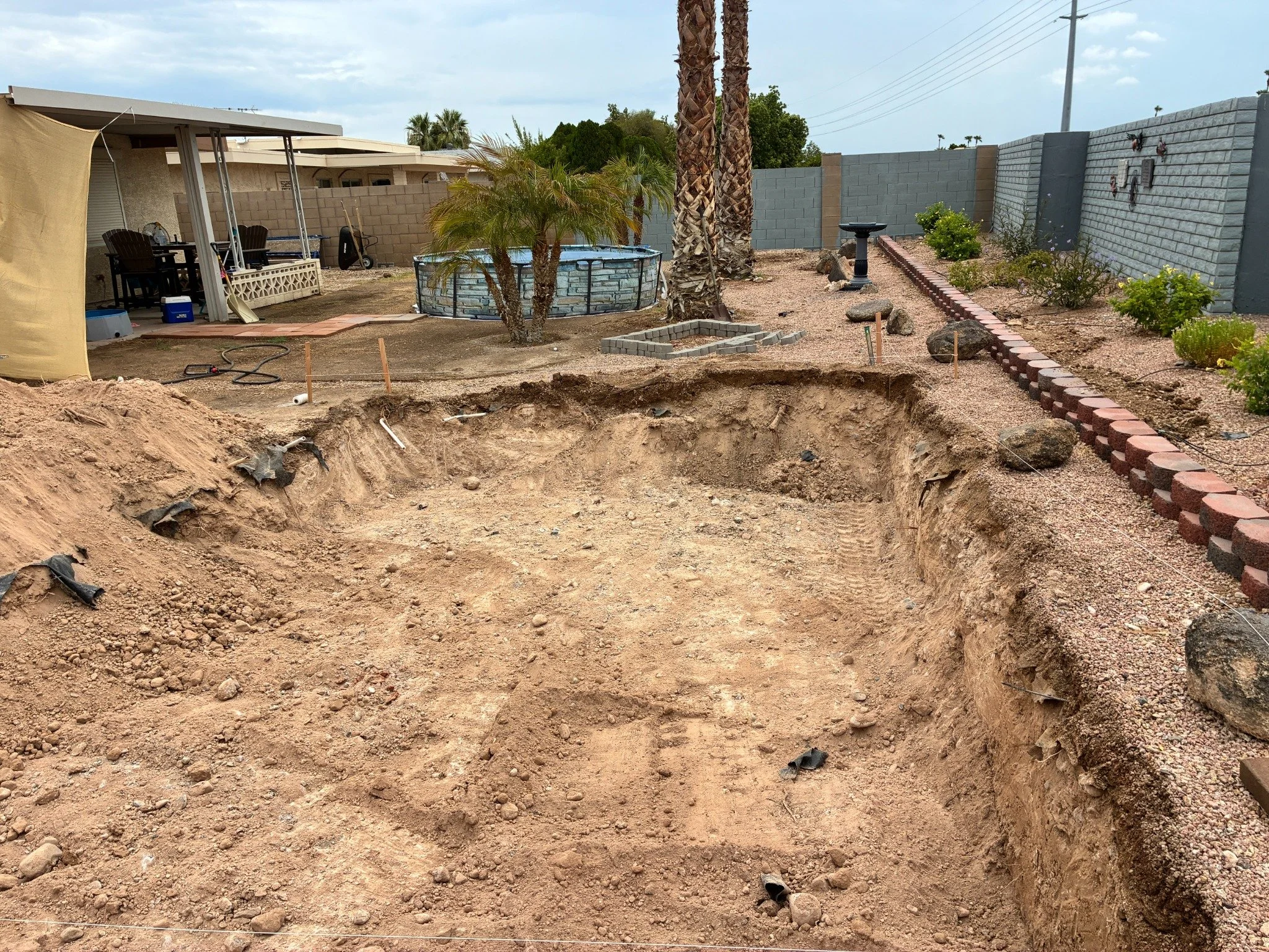 Residential pool excavation showing the full pool shape and stepped depth