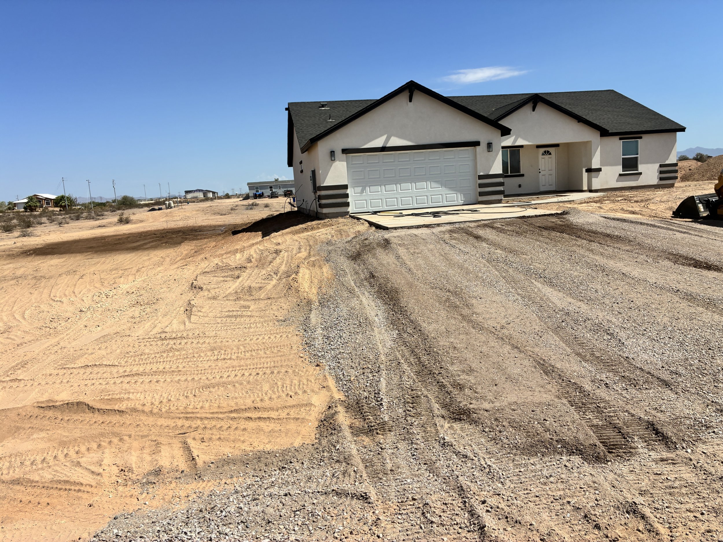 Graded swale transition channeling runoff beside an Arizona residence