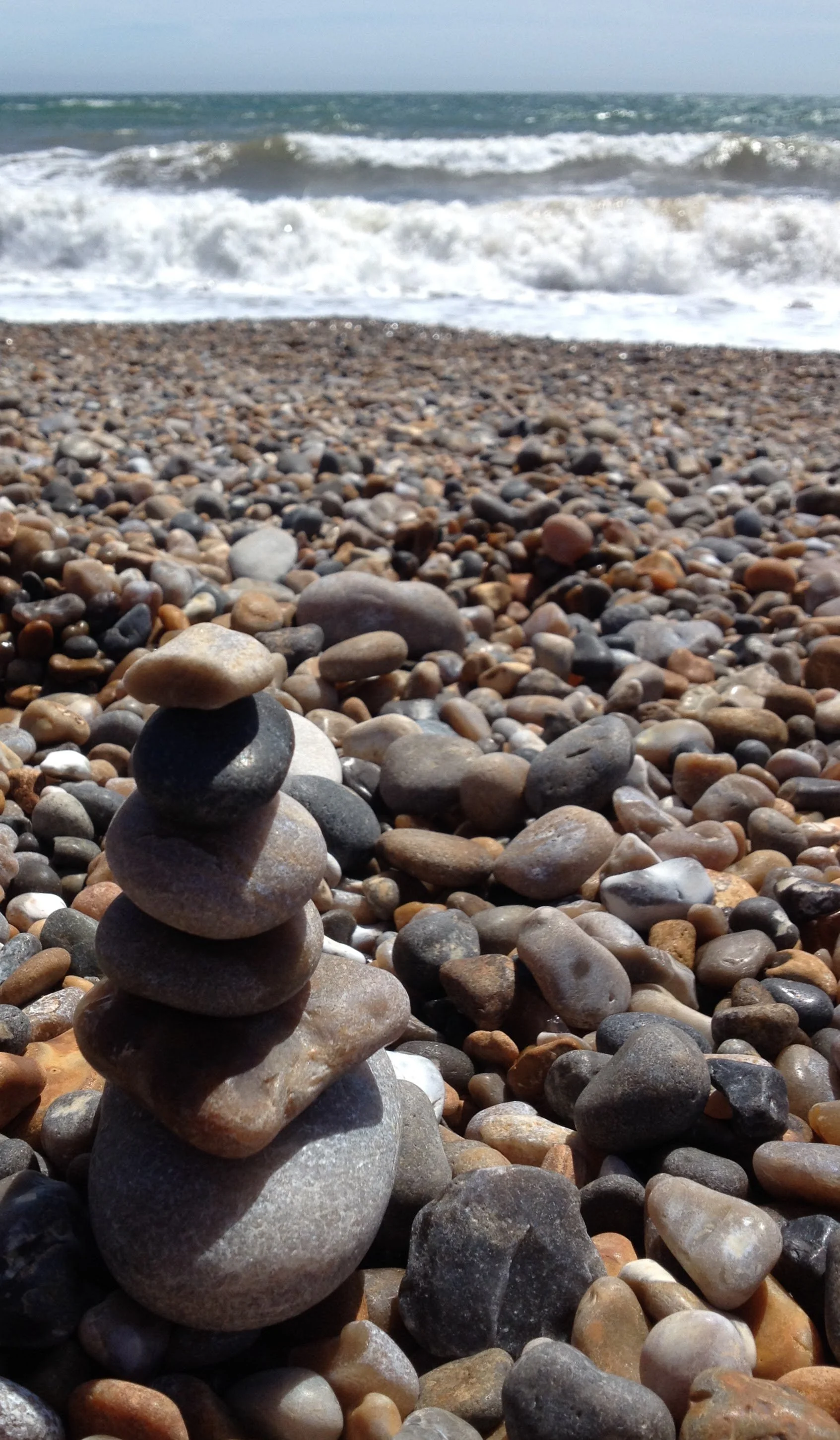 A photo of a tower of pebbles lying on a pebble beach