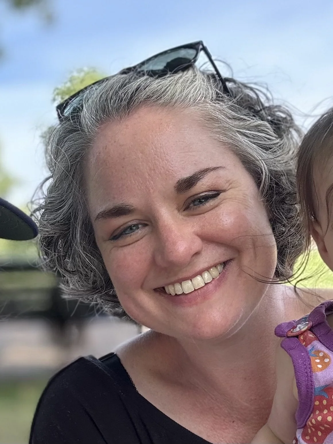 Photo of woman smiling at the camera. She is the owner of Gentle Wonder Baby.