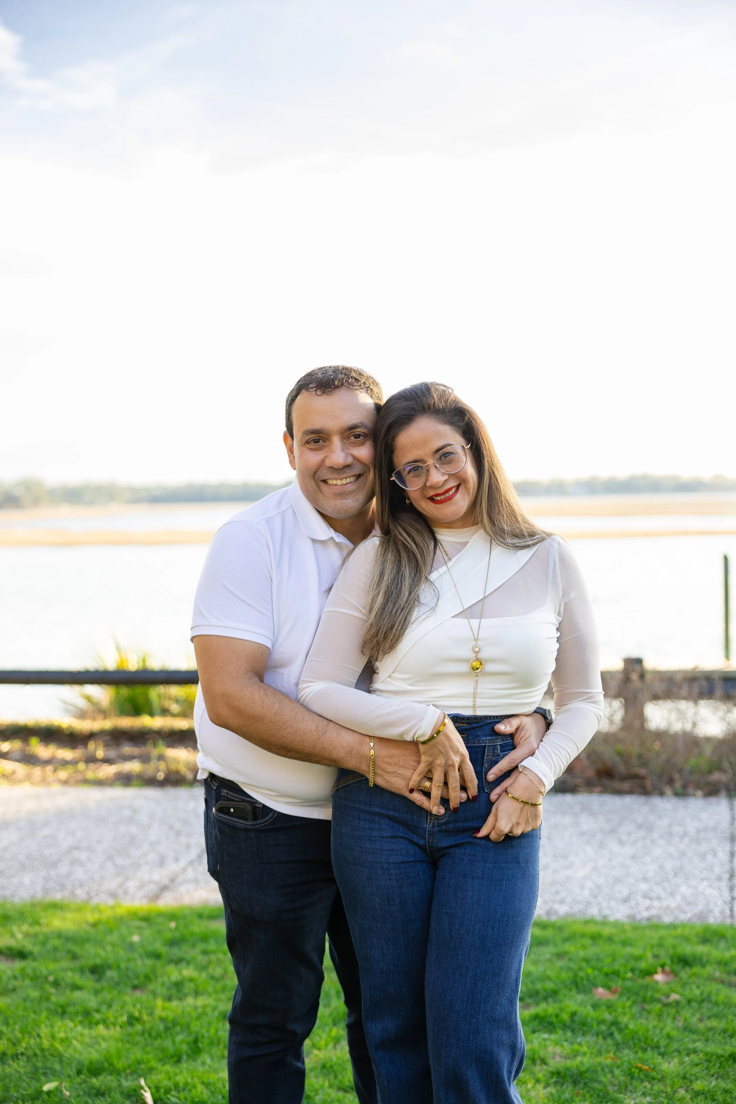 Angelica and Victor, co-owners of World Painting & Remodeling, standing outdoors near the water.