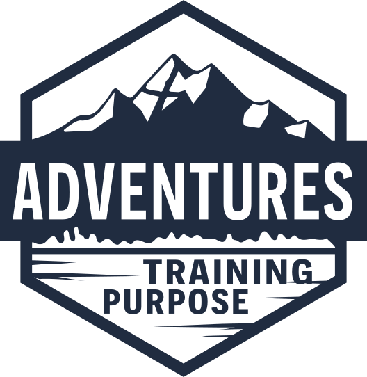 A logo with a mountain range and lake scene, containing the words 'Adventures Training Purpose' inside a hexagon outline.