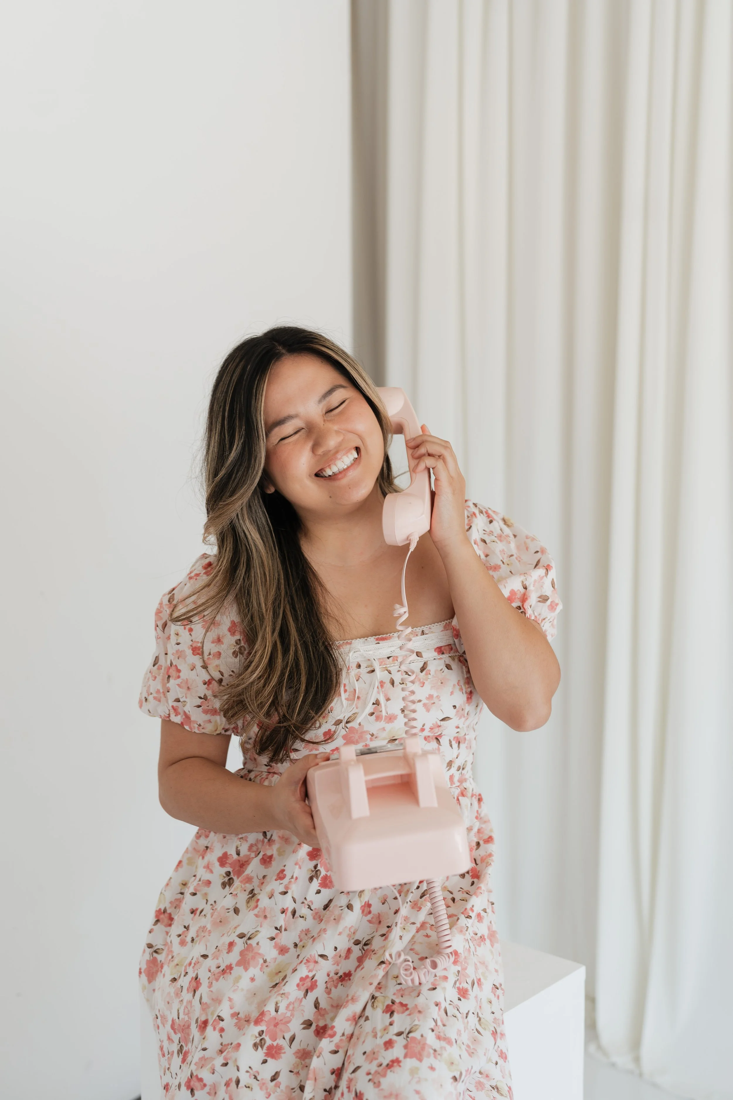 Therapist Minh Ngo holding a pink telephone in her Houston therapy office.
