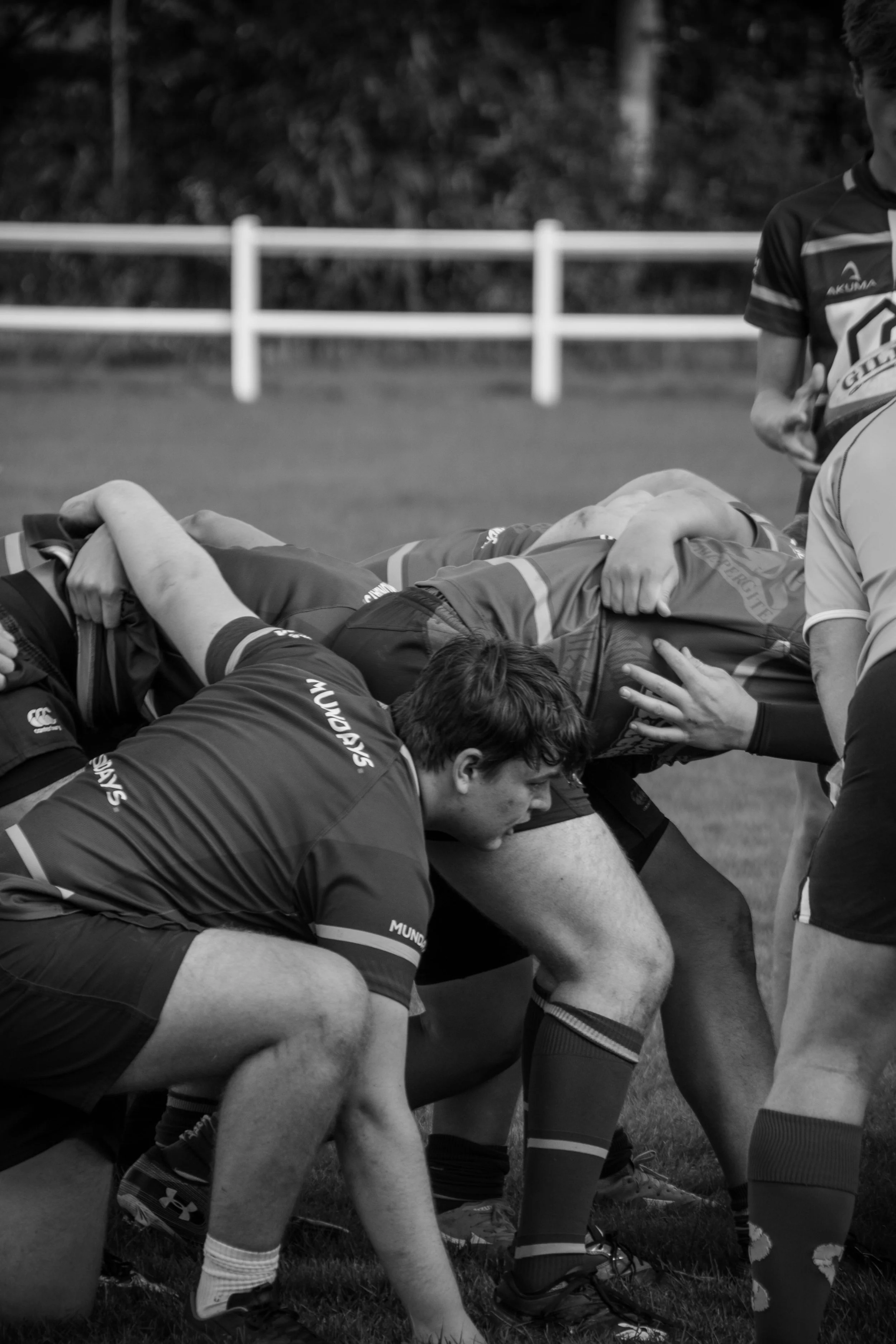 Rugby team preparing for a scrum on the field, with players in uniform in a crouched stance, ready to engage during a match or practice.