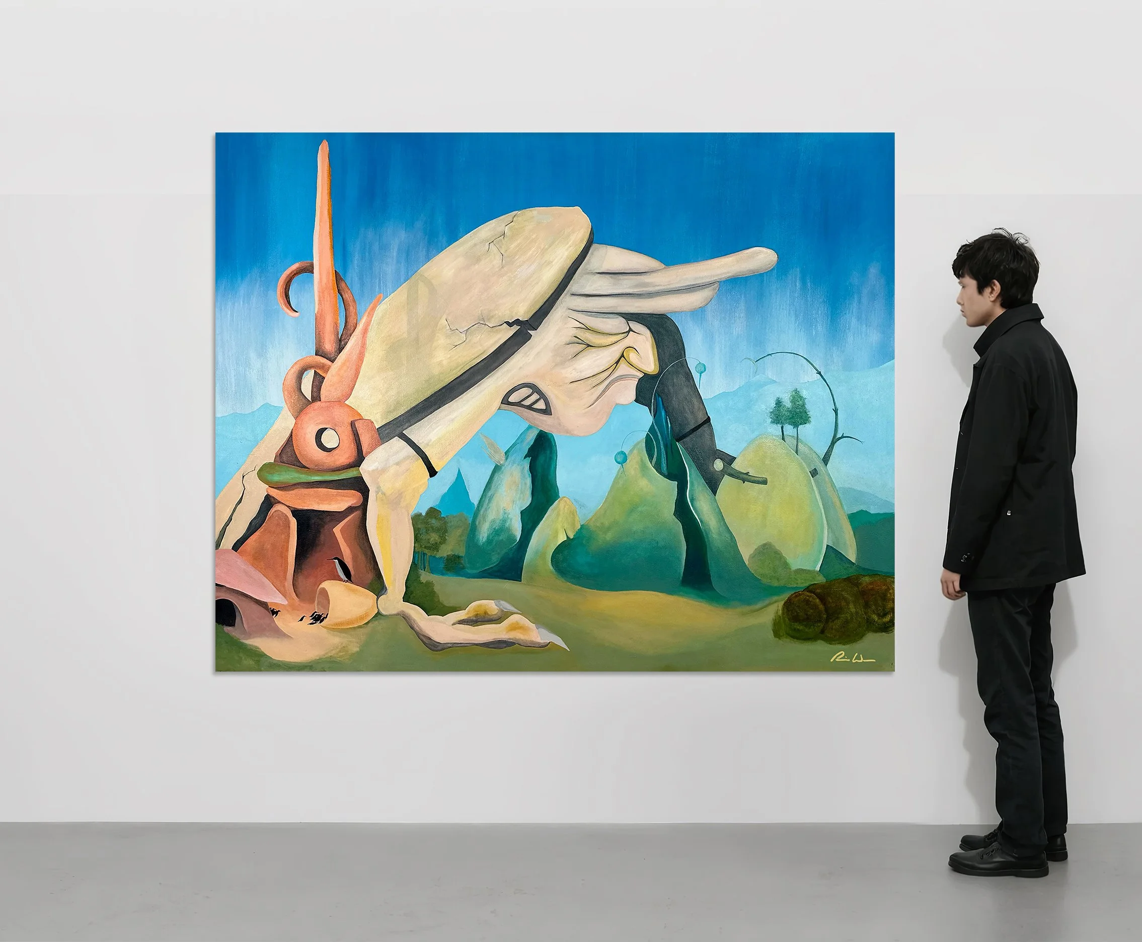 A person with black hair in a black jacket stands next to a large, vibrant painting on a white wall. The painting features a stylized profile of a woman's face with flowing hair, set against a blue sky and green landscape background.