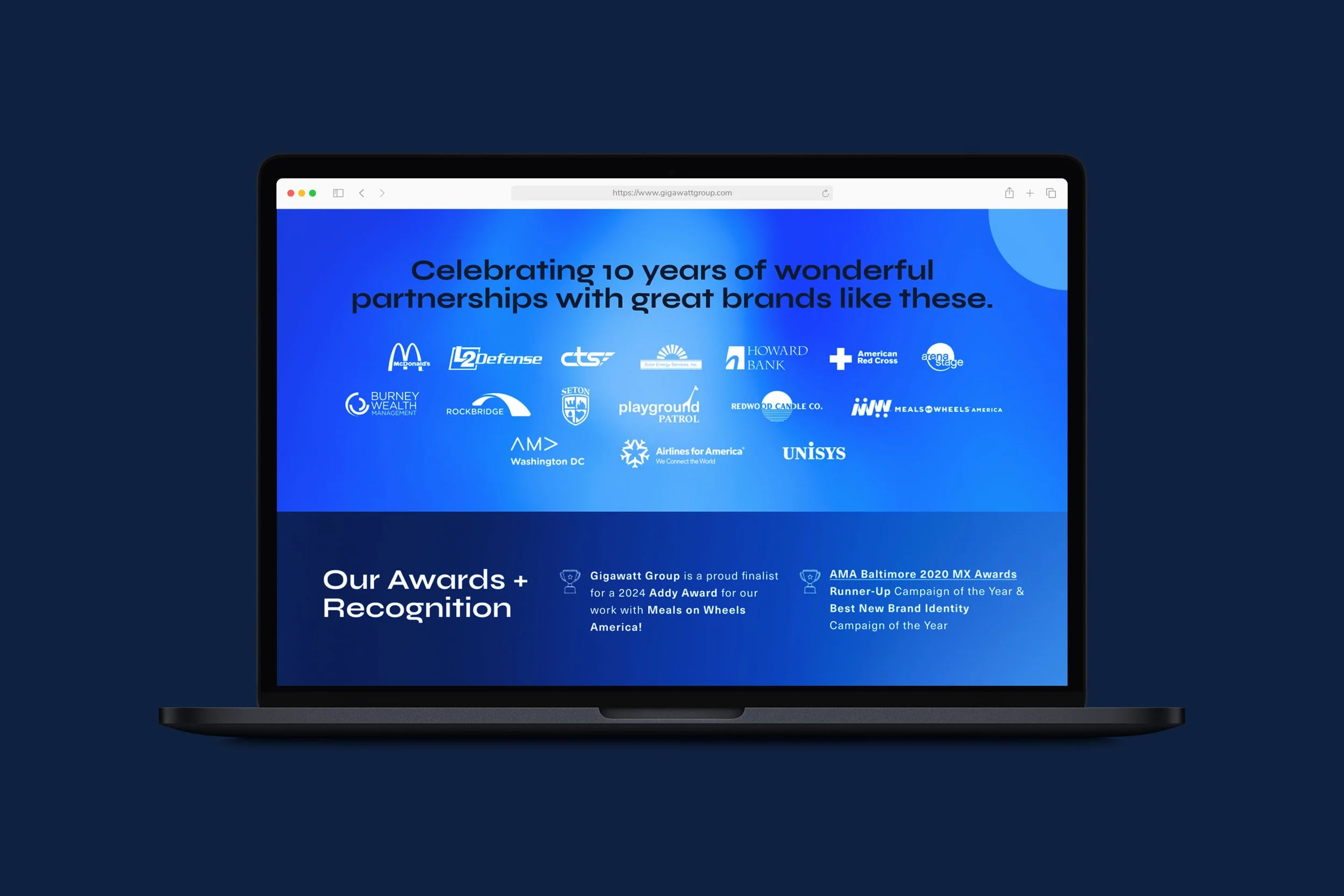 Gigawatt Group website UI UX design homepage desktop layout on a MacBook mockup showcasing the client logo wall celebrating 10 years of partnerships and the Awards and Recognition section highlighting 2024 Addy Award and AMA Baltimore 2020 MX Awards.