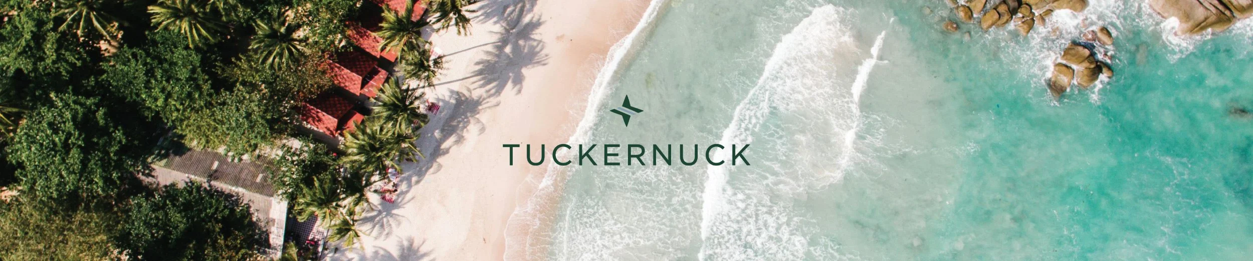 Tuckernuck brand header banner with aerial drone photography of a tropical beach resort, white sand shoreline, turquoise ocean waves, and lush palm trees, overlaid with the dark green Tuckernuck logo and wordmark.