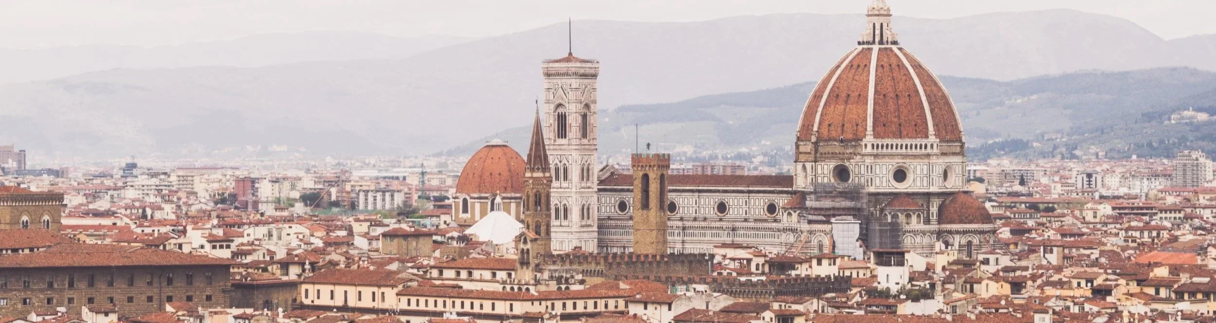 Brianna Cariola photography brand identity logo application cover mockup featuring a soft aerial travel photograph of the Florence Cathedral dome and Giotto's Campanile skyline.