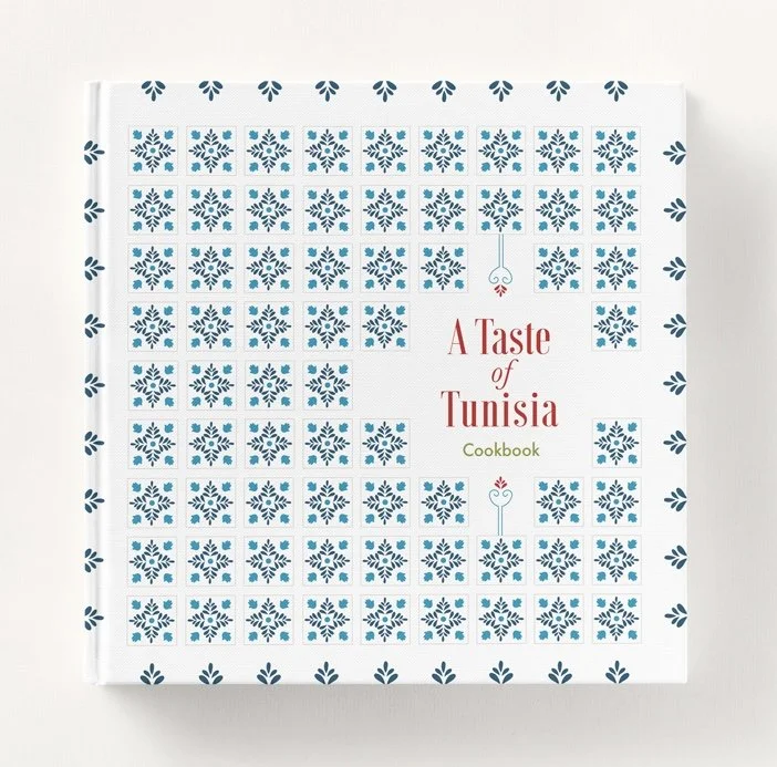 A Taste of Tunisia cookbook cover design featuring a repeating blue and white Tunisian zellige tile pattern with decorative spoon illustrations and bold red and green title typography on a white hardcover.