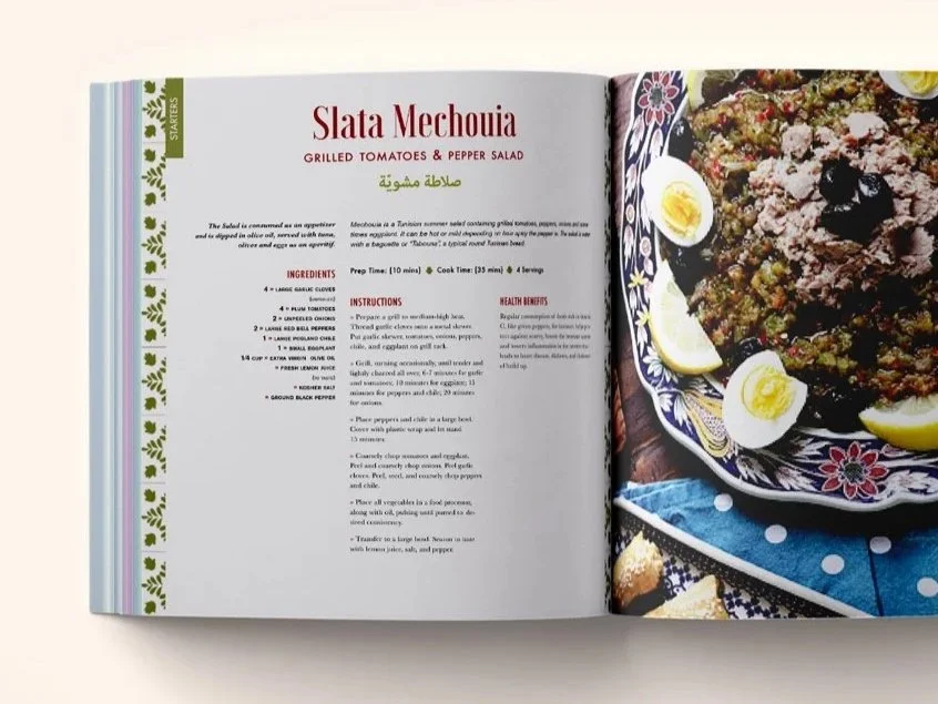 A Taste of Tunisia cookbook interior spread layout showing the Slata Mechouia grilled tomato and pepper salad recipe page with bilingual Arabic and English text alongside a full-bleed photo of the traditional Tunisian dish served on decorative plate.