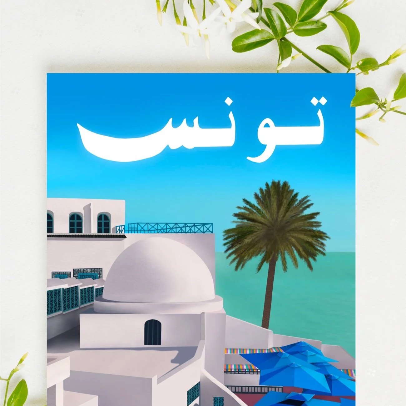 Sidi Bou Said Tunisia travel art print illustration mockup featuring white-washed domed architecture, teal balcony railings, a palm tree, and turquoise Mediterranean sea view under a bright blue sky with large bold Arabic lettering spelling Tunisia.