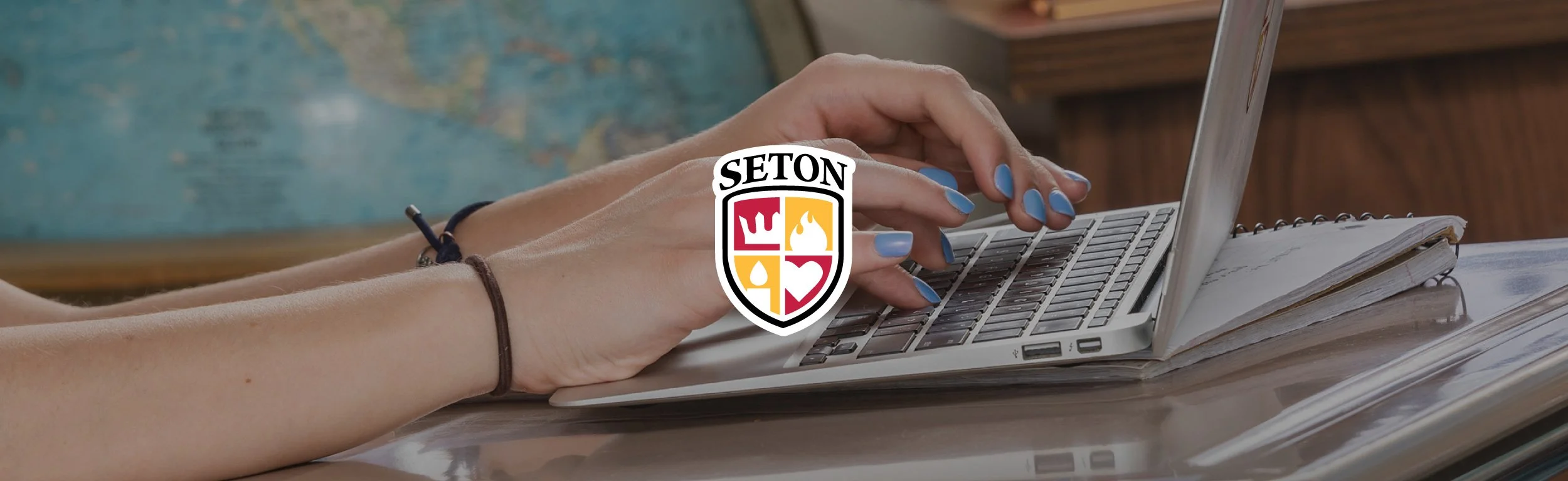 Elizabeth Seton High School branding displayed over student typing on laptop, representing digital learning and academic experience.