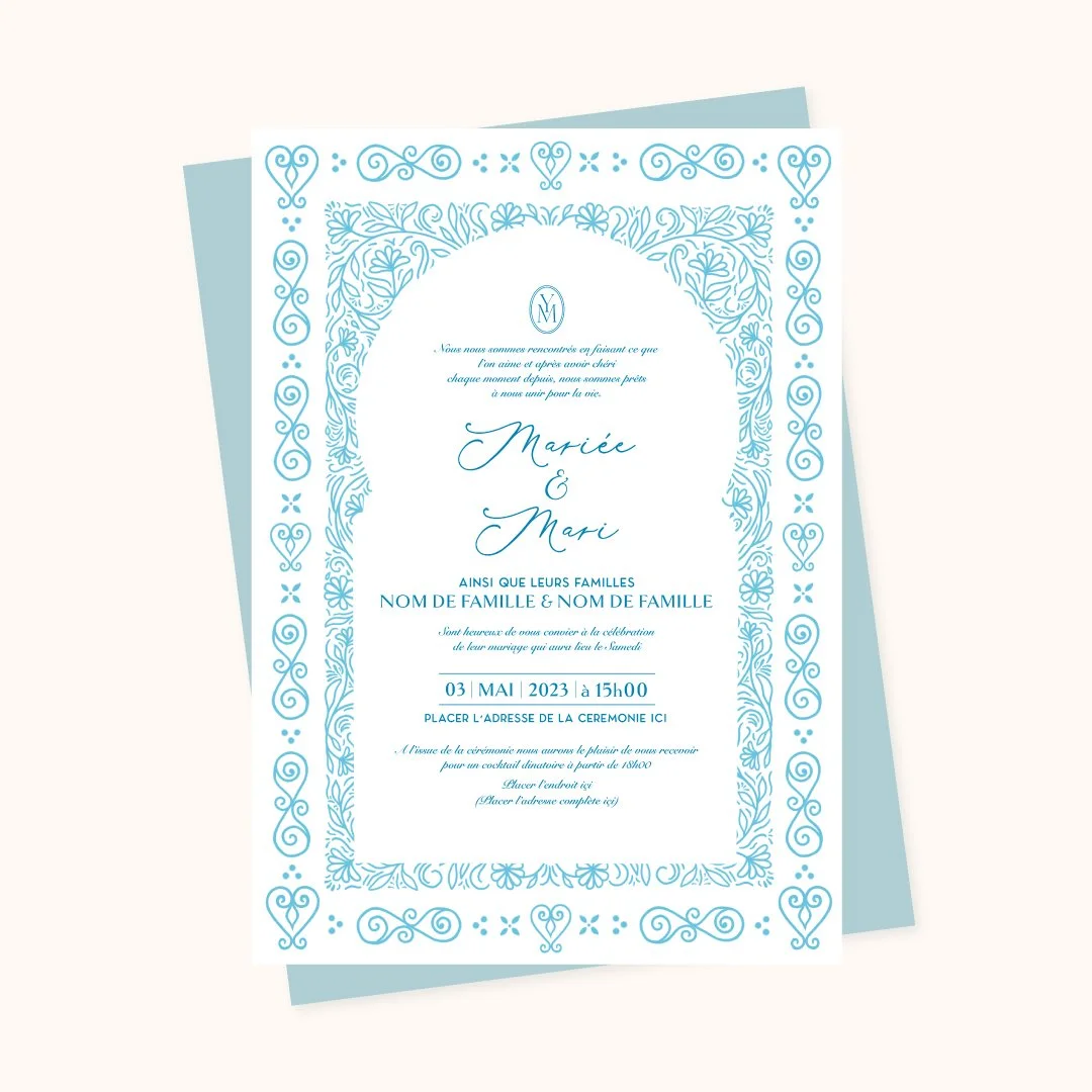 Sidi Bou Said-inspired Tunisian wedding invitation design in powder blue featuring an ornamental hand-drawn floral and arabesque arch border frame with elegant calligraphy script, shown with a matching blue envelope backing.