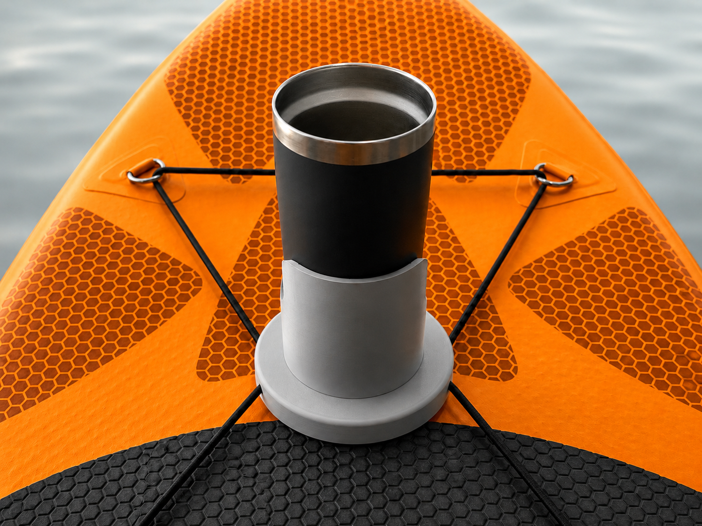 Close-up of an orange paddleboard with a mounted black and gray exhaust pipe, set against a water background.